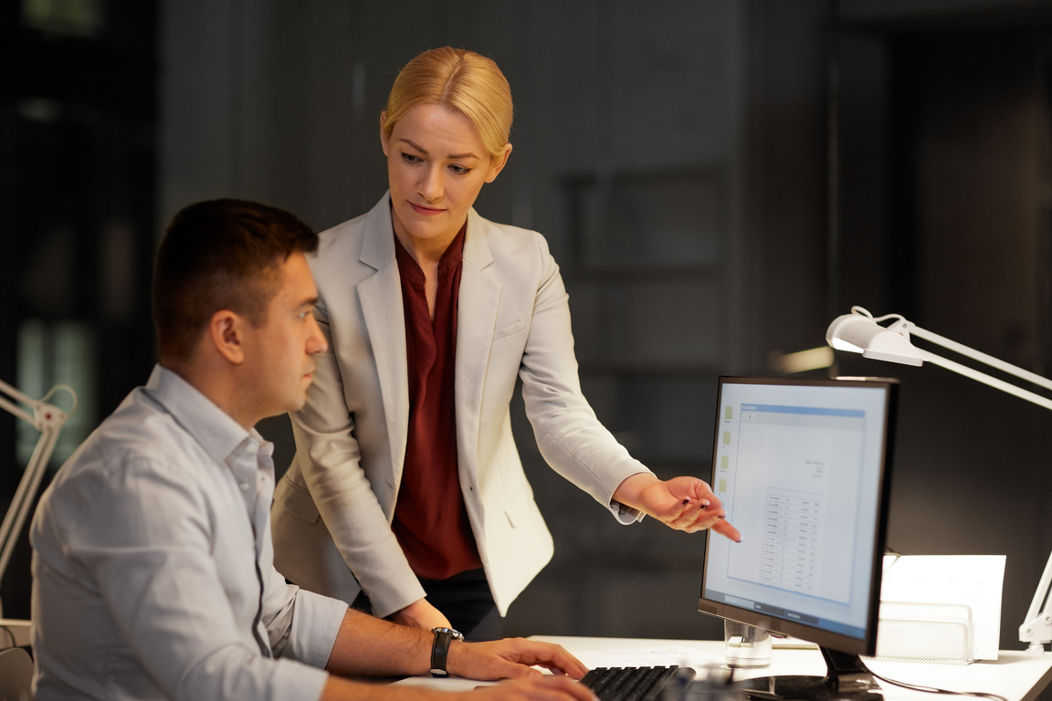 Business Team with Computer Working Late at Office
